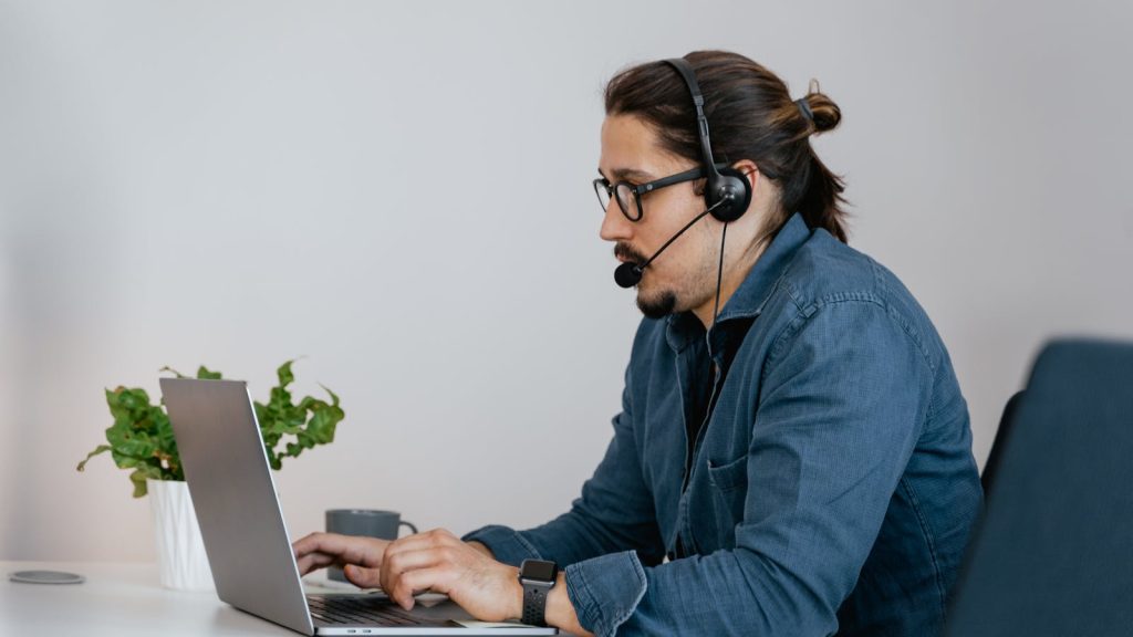 Profesional de soporte trabajando con un portátil para responder preguntas frecuentes en una web WordPress